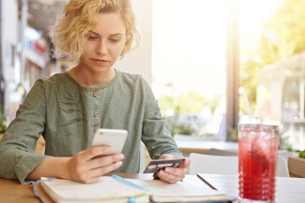 Woman using smartphone to check balance online in Fab Bank