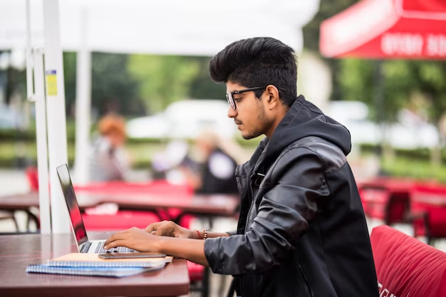  Young student with a laptop participating in a freelance project in Dubai
